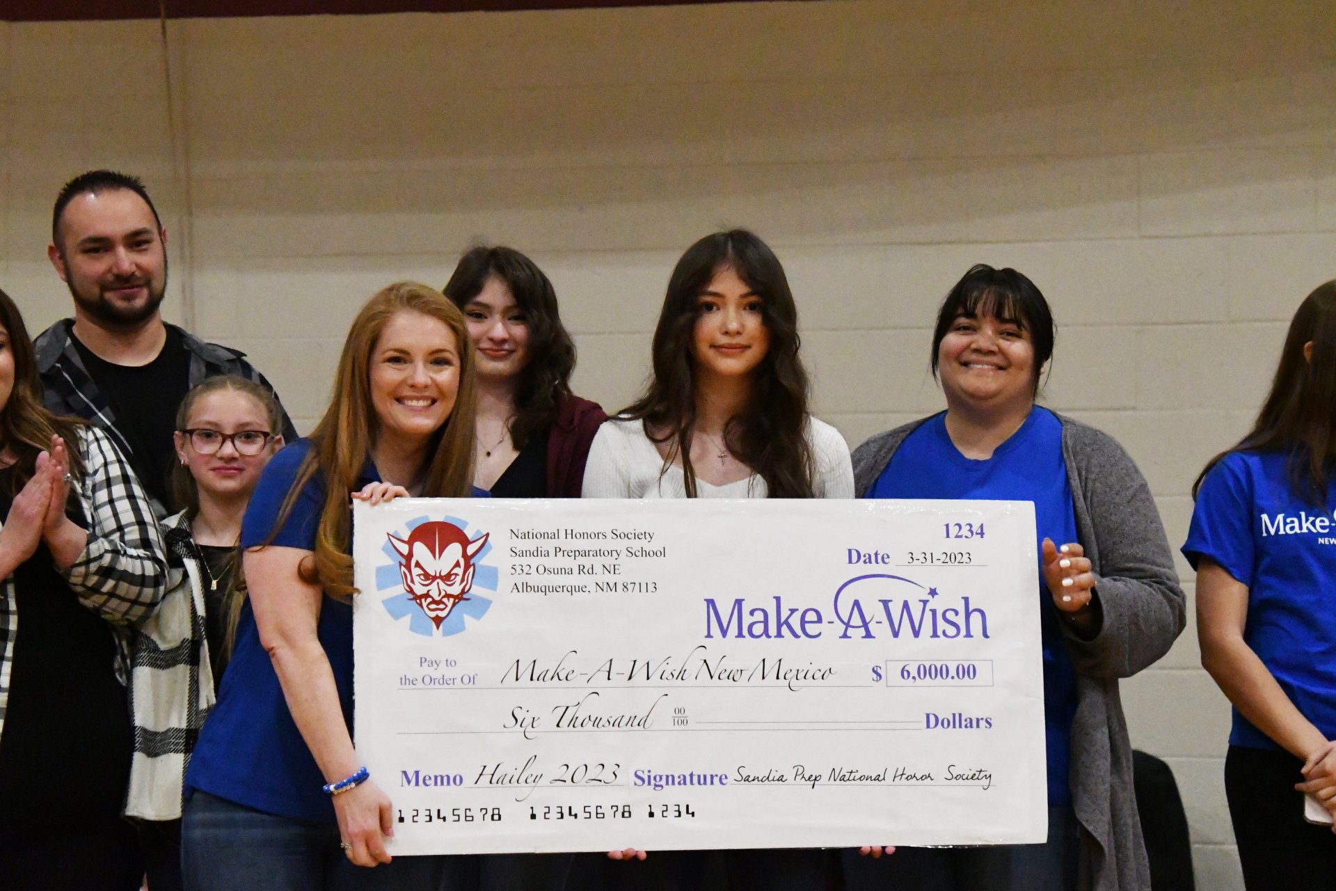 Make-A-Wish staff accepts check from Sandia Prep NHS for Wish Kid f